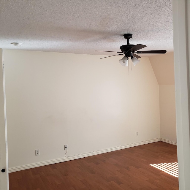 spare room with ceiling fan, lofted ceiling, dark hardwood / wood-style flooring, and a textured ceiling