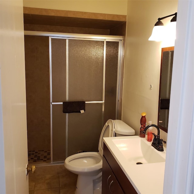 bathroom featuring walk in shower, vanity, toilet, and tile patterned flooring