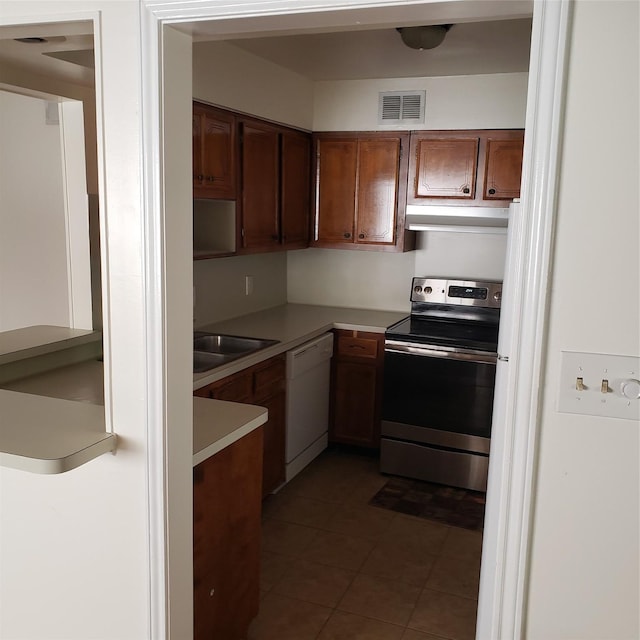 kitchen with sink, electric range, dark tile patterned floors, and dishwasher