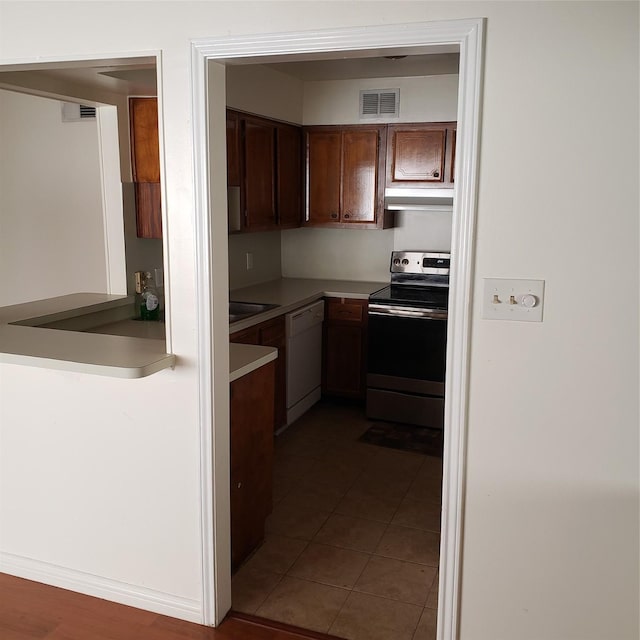 kitchen with stainless steel electric stove, dark tile patterned flooring, and white dishwasher