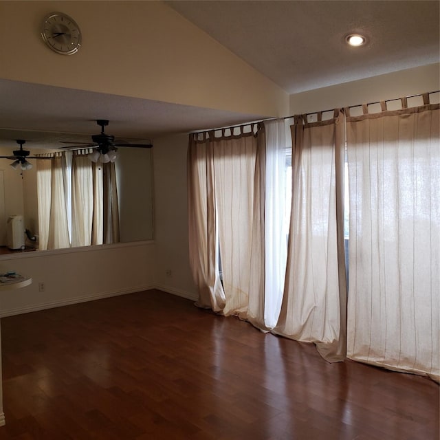 spare room with lofted ceiling and dark wood-type flooring