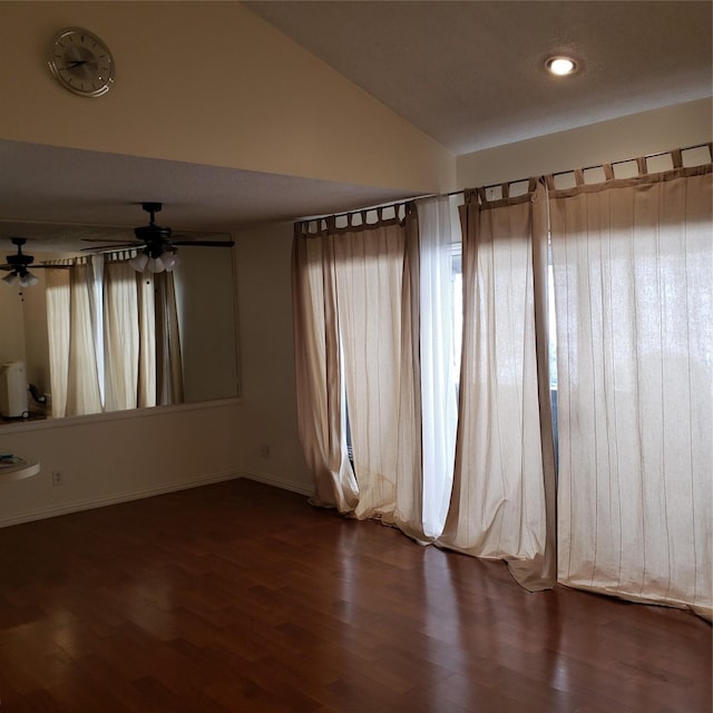 unfurnished room featuring dark wood-type flooring and vaulted ceiling