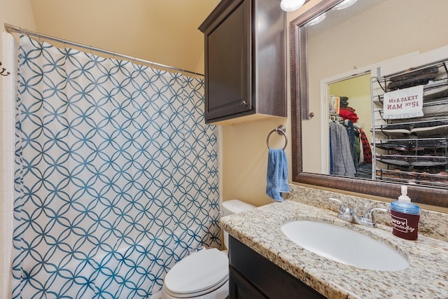 bathroom with vanity, a shower, and toilet