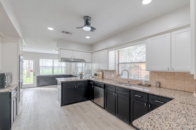 kitchen featuring sink, white cabinets, decorative backsplash, light stone counters, and stainless steel appliances