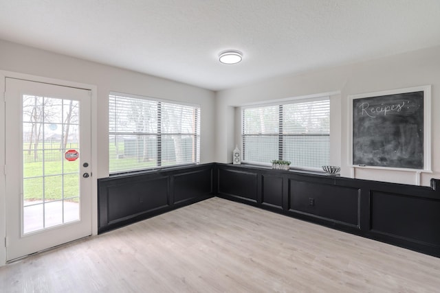 interior space featuring plenty of natural light, a textured ceiling, and light wood-type flooring