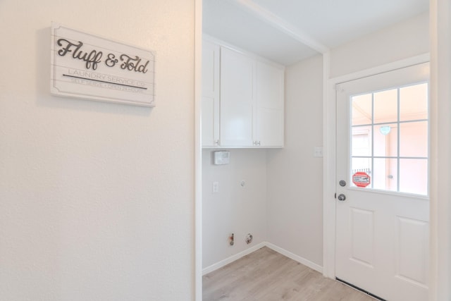 laundry room with cabinets, gas dryer hookup, and light hardwood / wood-style flooring