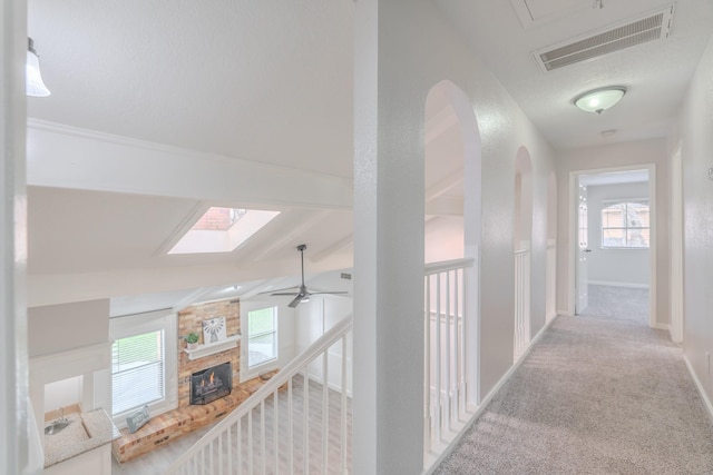 hallway featuring lofted ceiling and light carpet