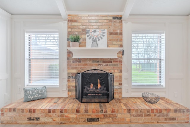 interior details featuring a fireplace, ornamental molding, and beamed ceiling