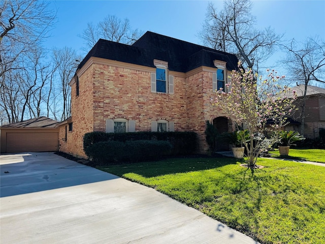 view of home's exterior with an outbuilding, brick siding, a lawn, and a garage