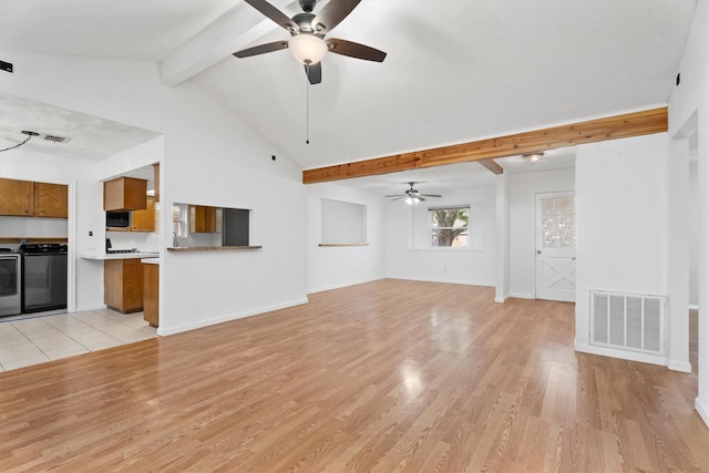 unfurnished living room with ceiling fan, separate washer and dryer, lofted ceiling with beams, and light wood-type flooring