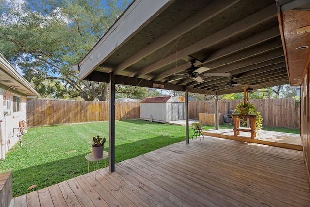 wooden deck with a yard, ceiling fan, and a storage unit