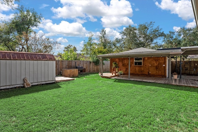 view of yard featuring a deck and a storage unit