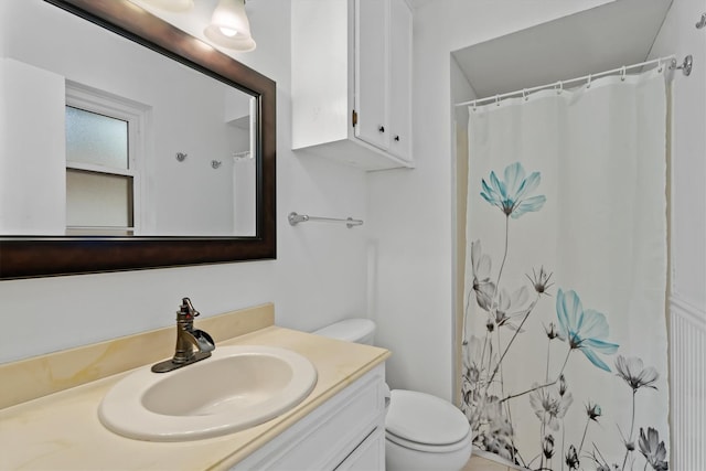 bathroom with vanity, toilet, and curtained shower