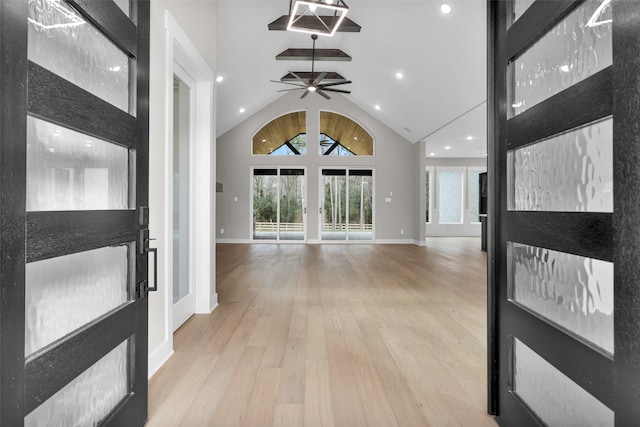 entryway with light hardwood / wood-style flooring, high vaulted ceiling, and ceiling fan