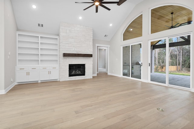 unfurnished living room featuring high vaulted ceiling, a fireplace, ceiling fan, and light hardwood / wood-style flooring