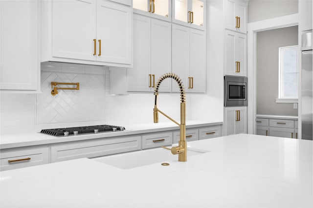 kitchen featuring white cabinetry, stainless steel appliances, sink, and tasteful backsplash