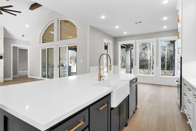 kitchen featuring sink, white cabinetry, a center island with sink, ceiling fan, and light hardwood / wood-style floors