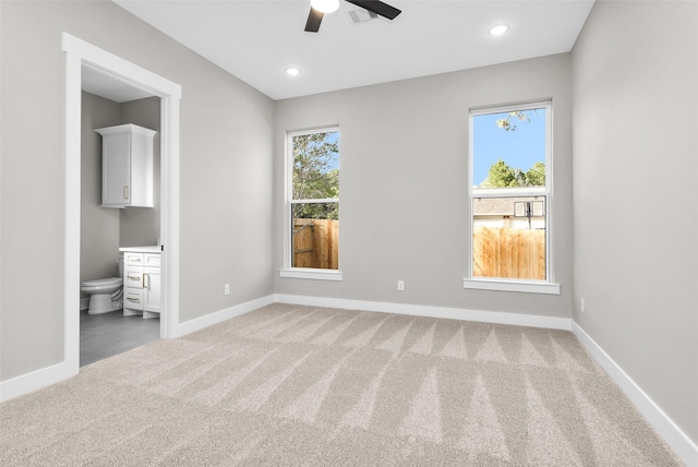 unfurnished bedroom featuring carpet floors, ceiling fan, and ensuite bathroom