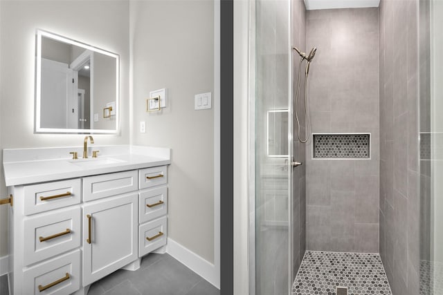 bathroom with tile patterned flooring, vanity, and tiled shower