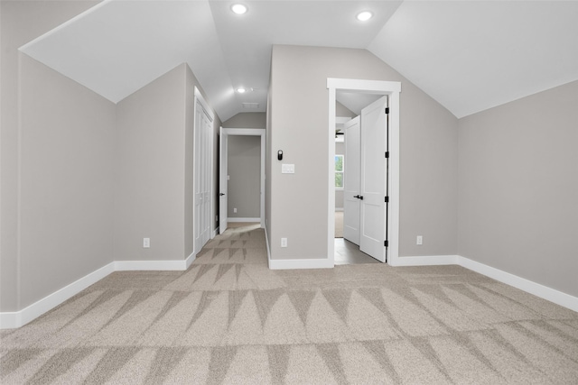 unfurnished bedroom with lofted ceiling and light carpet