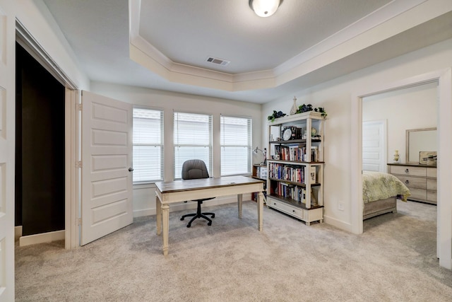 home office featuring a raised ceiling, ornamental molding, and light colored carpet