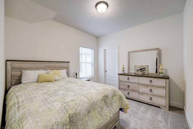 carpeted bedroom with lofted ceiling