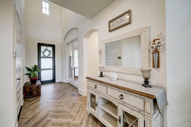 entrance foyer featuring light parquet floors and a high ceiling