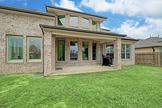 rear view of property with a lawn and a patio