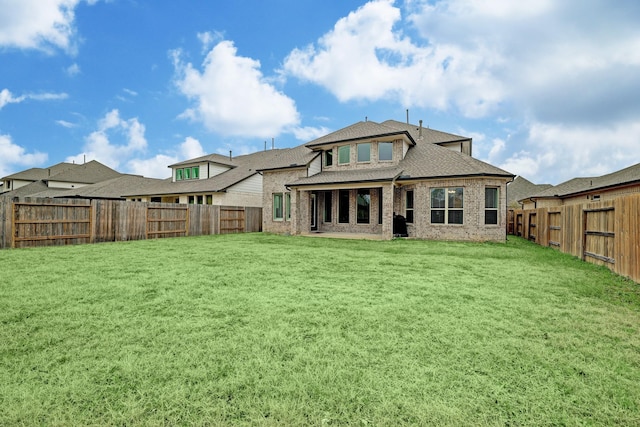 rear view of property featuring a lawn