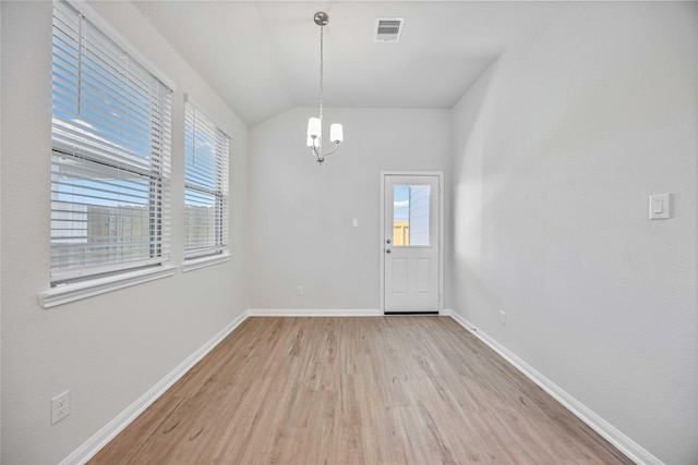 interior space featuring vaulted ceiling, a chandelier, and light hardwood / wood-style floors