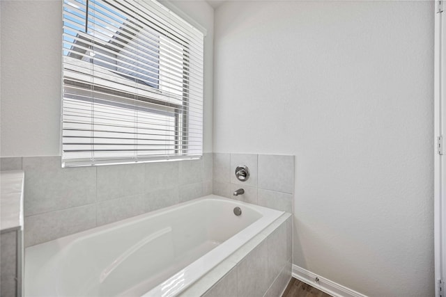 bathroom featuring a relaxing tiled tub