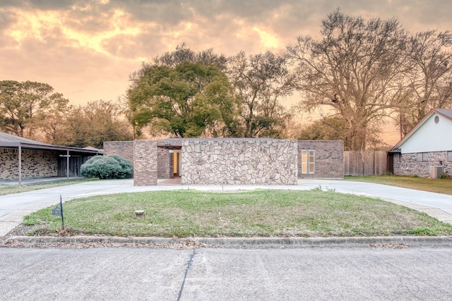 view of front of home featuring a lawn and central air condition unit