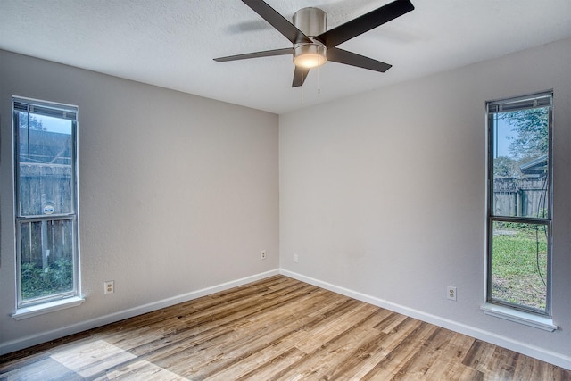 empty room with a textured ceiling, light hardwood / wood-style flooring, and ceiling fan