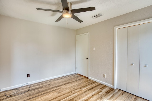 unfurnished bedroom featuring a closet, ceiling fan, and light wood-type flooring