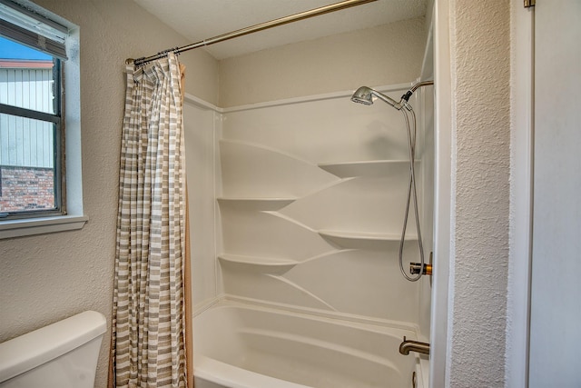 bathroom featuring shower / bathtub combination with curtain and toilet