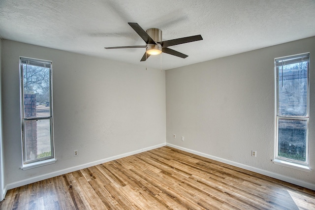 unfurnished room with ceiling fan, plenty of natural light, light hardwood / wood-style floors, and a textured ceiling