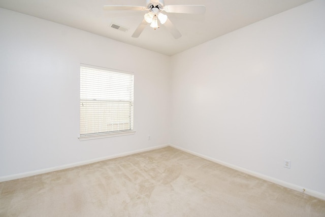 spare room featuring light carpet and ceiling fan