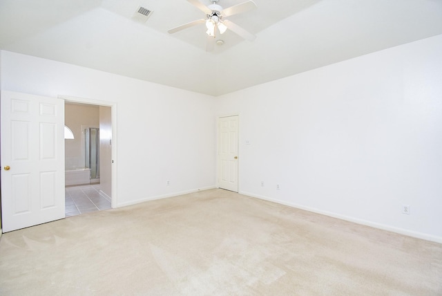 carpeted spare room featuring ceiling fan and a tray ceiling