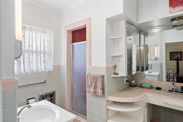 bathroom with vanity, an enclosed shower, crown molding, and tile walls