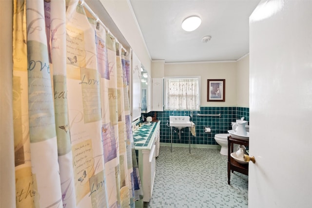 bathroom with toilet, sink, a shower with curtain, tile walls, and ornamental molding