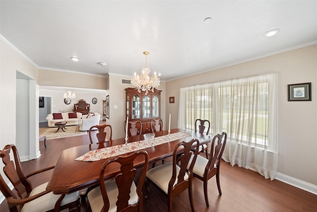 dining room featuring crown molding, hardwood / wood-style flooring, and a chandelier