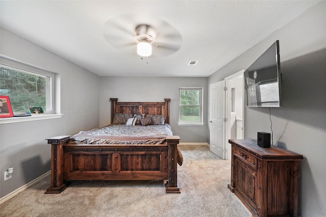 bedroom featuring light carpet, connected bathroom, and ceiling fan