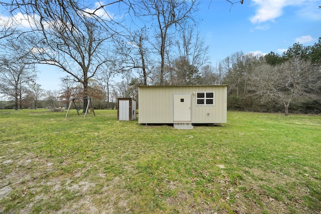 view of outdoor structure with a yard and a playground