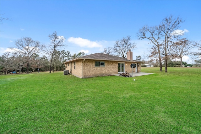 rear view of property with central AC, a lawn, and a patio