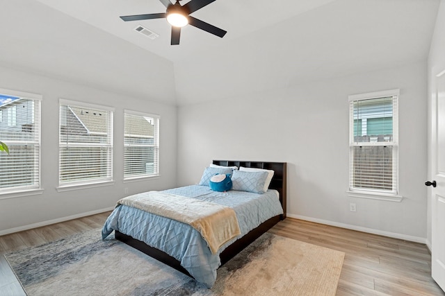 bedroom with ceiling fan, light hardwood / wood-style floors, and vaulted ceiling