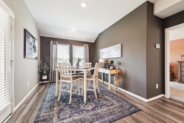 dining room with dark hardwood / wood-style flooring and vaulted ceiling