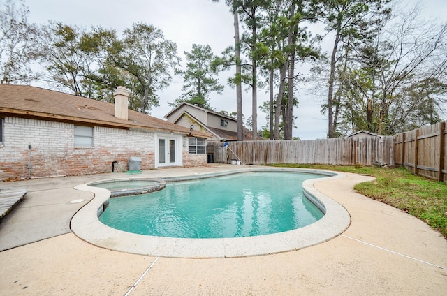 view of swimming pool with a patio, a fenced backyard, and a pool with connected hot tub