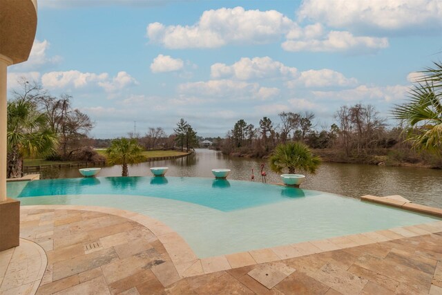 view of pool featuring a patio area and a water view