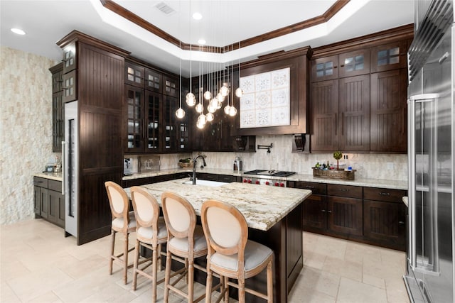 kitchen featuring visible vents, a tray ceiling, stainless steel appliances, and a sink