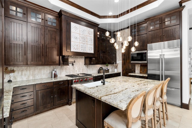 kitchen featuring dark brown cabinetry, a sink, decorative backsplash, and built in appliances